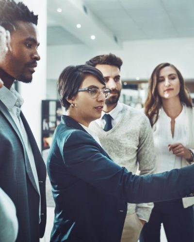 Shot of a group of focused businesspeople having a discussion while making use of a glass white board to go through notes